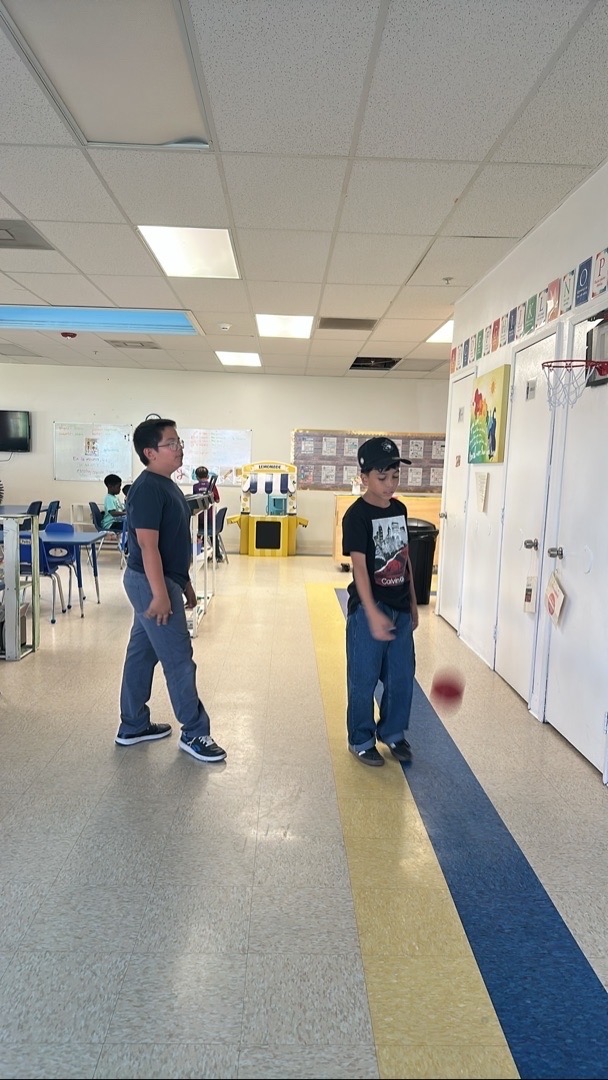 Children playing with a basketball near an indoor hoop
