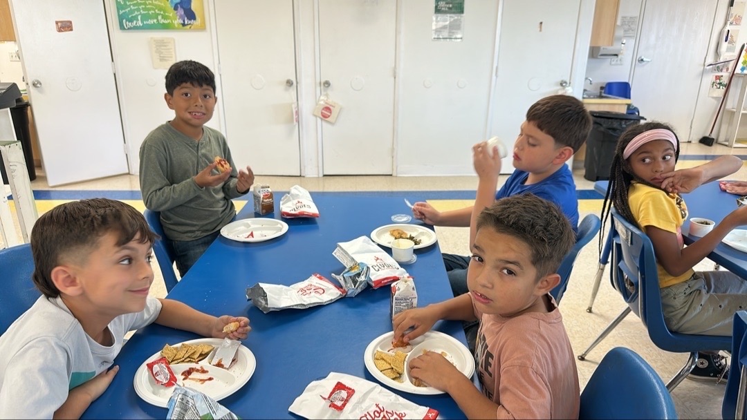 Children sharing mealtime at a classroom table